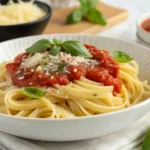 Pasta sin gluten con salsa casera de tomate y albahaca en un plato blanco.