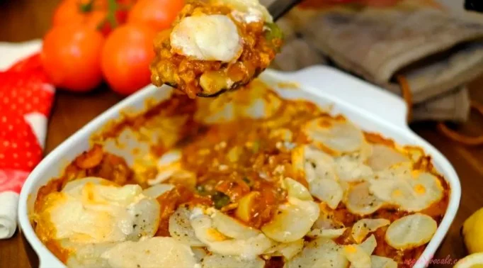 Plato de lasaña de papa sin gluten con ingredientes frescos y coloridos.